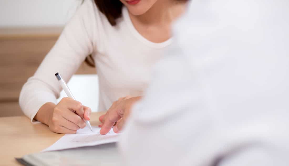 dental patient signing papers at Lindenhurst Dental Health Group 